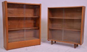 Two 20th Century freestanding closed bookshelves each having glass sliding doors with two shelves