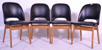 A good set of four retro 20th Century black covered rexine dining chairs of shaped form raised on