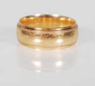 A 9ct gold wedding band ring having beaded decoration to the edges. Marked 375, makers mark PHW.