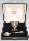 A silver hallmarked engraved child's egg cup and spoon christening set, the spoon and cup each chase