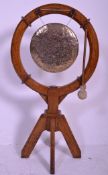 An unusual early 20th century Arts & Crafts oak floor standing gong. The oak heavy stand on tripod
