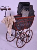 A 20th Century Victorian style toy / dolls pram having a black rectangular body with red metal
