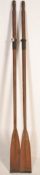A large pair of early 20th Century decorative pine boat oars with metal banding and shaped ends.