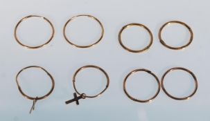 A selection of 9ct gold sleeper hoop earrings to include a pair with crucifix drops. Eight in total.