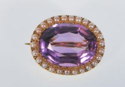 A 20th Century 15ct gold brooch set with faceted oval cut amethyst with a halo of seed pearls set to