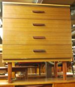 A 1960's retro vintage teak wood veneered chest of drawers. The bank of four drawers raised on