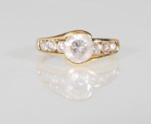 An English hallmarked 9ct yellow gold ladies ring set a central round faceted cut CZ flanked by