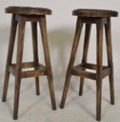 A pair of vintage 20th Century oak leather topped bar stools raised on tapering legs united by