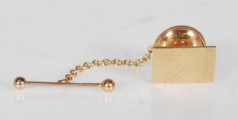 A hallmarked 9ct gold tie clip having a rectangular head with engraved decoration and a T bar of