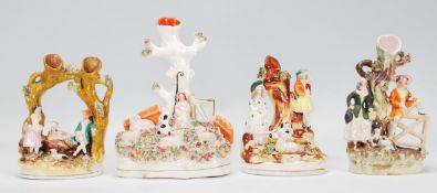 A group of four 19th Century Victorian Staffordshire spill / tulip vases each adorned with figures