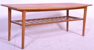 A retro 20th Century Danish inspired surfboard top teak coffee table raised on tapering legs with