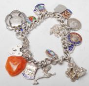 A Silver hallmarked charm bracelet having a curb link chain having 19 charms including a large