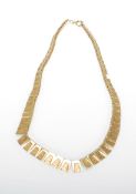 A stamped 375 9ct gold collar necklace having rectangular panels with bark effect design, spring