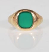 A hallmarked 9ct gold signet ring having a rectangular green stone panel to the head. Hallmarked