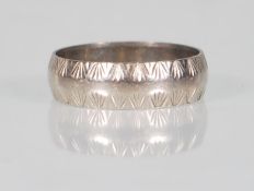 A hallmarked 18ct white gold band ring having engraved decoration to the borders. Hallmarked