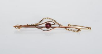 A stamped 9ct gold bar brooch having pierced design centre set with a round cut pink stone. Set on a