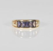 A 9ct yellow gold ladies ring having a split mount set with rectangular faceted cut purple stones