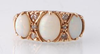 A 9ct gold opal and diamond ring. The ring set with three oval opal cabochons having diamond spacers