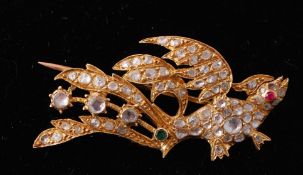 A 19th century gold and diamond figural bird brooch. The brooch in the form of a mythical bird