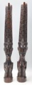 A pair of 20th Century carved dark wood African tribal figurines in the form of stylised crouched