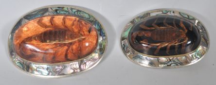 Two vintage 20th Century American silver belt buckles with abalone shell inlaid board and resin