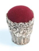 A stamped 925 silver pin cushion in the form of a basket having raised floral decoration with a