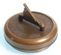 A brass cased Gilbert pocket sundial and compass, the round case opening to reveal the compass