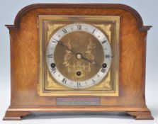 A good early 20th Century Art Deco Elliott oak and walnut cased mantel clock having a brass face