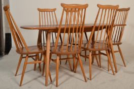 Ercol - A vintage 20th Century blonde beech and elm wood refectory plank dining table being raised