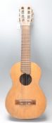 A good vintage 20th Century Yamaha childs six string acoustic guitar having a shaped hollow body