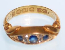 A early 20th Century hallmarked 18ct gold ring set with three round cut sapphires with four small