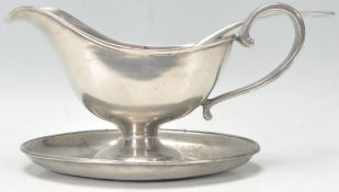 An early 20th Century French good quality pewter sauce boat and stand. Together with a matching