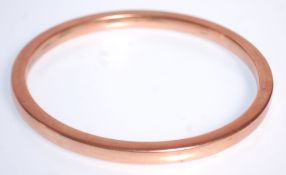A large hallmarked 9ct gold slave bangle of plain form. Hallmarked for Birmingham date letter Z.