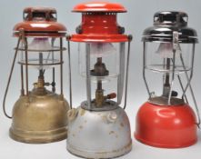 A collection of early 20th century Tilley lamps to include grey, gold and red enamel painted