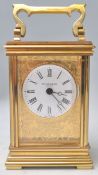 A good brass cased carriage clock with decorative applied brass work depicting birds and floral
