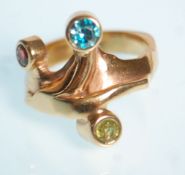 An unusual 9ct yellow gold ring set with a red, green and blue round cut stones set to a