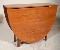 A retro 1970's teak wood Danish influenced G-Plan drop leaf dining table raised on shaped supports