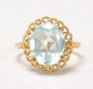 An 18k yellow gold ladies dress ring having a decorative scroll wire worked mount set with a central