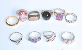 A group of ten silver rings to include a ring set with a large faceted white stone, a three stone