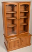 Ercol - A retro style beech and elm sideboard display cabinet comprising of a glazed twin door