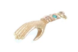 A late 19th Century Century unmarked gold hand charm having inlaid turquoise cabochons. Measures 2.