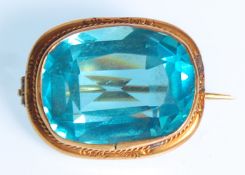 A Victorian 9ct gold ladies brooch set with a large faceted cut blue stone and rope twist