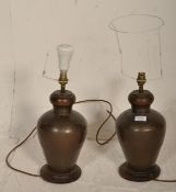 A pair of large planished brass / bronze lamps of Chinese form. The lamps / lights of baluster