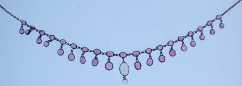 A late 19th Century gold necklace set with faceted garnet drops with a central moonstone drop.