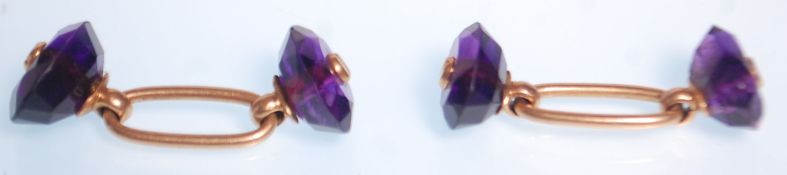 A pair of antique gold and amethyst cufflinks having oval cut amethysts united by gold connectors.