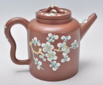 An early 20th Century Chinese brown clay teapot having hand enameled bird and floral decoration with