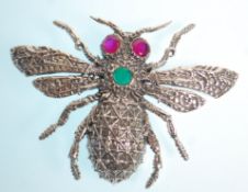 A stamped sterling silver bug brooch with moulded decoration set with ruby eyes and a round cut