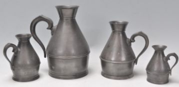 A graduating set of four 19th Century Victorian Irish pewter jugs of shapely form with scroll