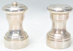 A pair of early 20th century Sterling silver condiments - salt and pepper. Each of conical form with