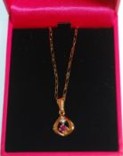 An 18ct gold pendant necklace having a tear drop pendant set with a round cut ruby and diamond.
